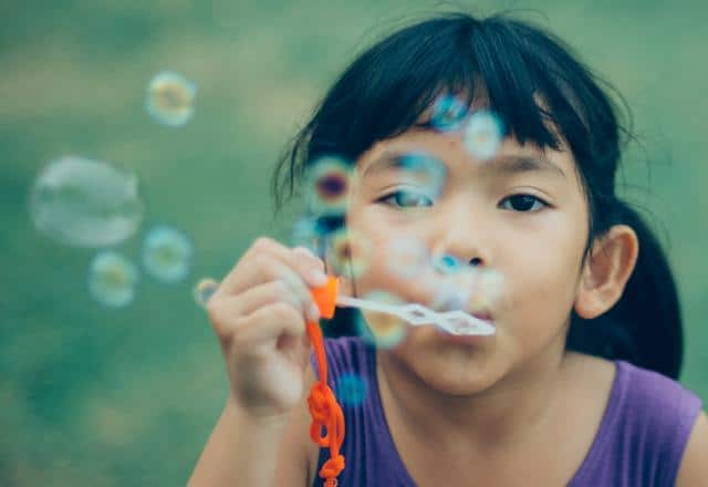 Fille soufflant des bulles de savon